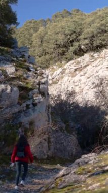 Güneşli bir kış gününde dağda yürüyüş yapan tanınmayan bir kadının dikey dikiz görüntüsü. Yüksek kaliteli FullHD görüntüler