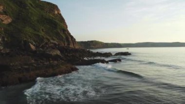 Gün batımında deniz kıyısı ve kayalık kayalıklar. Hava 4K görüntüleri. Yüksek kalite 4k görüntü