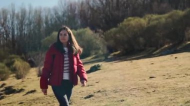 Kırmızı elbiseli güzel bir kadın doğa yürüyüşü yapıyor. Yakın çekim görüntüleri. Yüksek kaliteli FullHD görüntüler