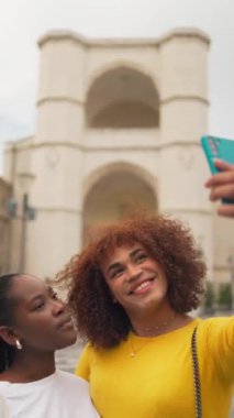 Latin bir bayan arkadaş, Avrupa 'nın ünlü mekanı üzerinde selfie çekiyor. Dikey eşuzay. Yüksek kalite 4k görüntü