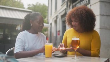 İki kadın arkadaş bir dilim pizza yiyip deneyimi paylaşıyorlar. Gen z yaşam tarzı. Yüksek kalite 4k görüntü