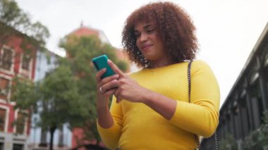 Şehir caddesinde cep telefonu kullanan transseksüel bir kadın. Aşağıdan bak. Uzayı kopyala Yüksek kalite 4k görüntü