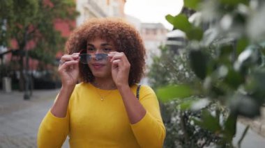 Modern nesil trans kadın güneş gözlüğü takıyor ve Downtown 'da gülümsüyor. LGTB çalışanları. Yüksek kalite 4k görüntü