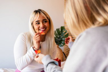 Kalp şeklinde şeker değiş tokuşu yapan iki mutlu kadın sevgililer gününü birlikte kutluyorlar.
