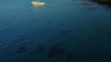 Alacakaranlıkta İtalya kıyı şeridinde birkaç yatı olan mavi denizin havadan görünüşü. 4K İHA görüntüleri. Yüksek kalite 4k görüntü