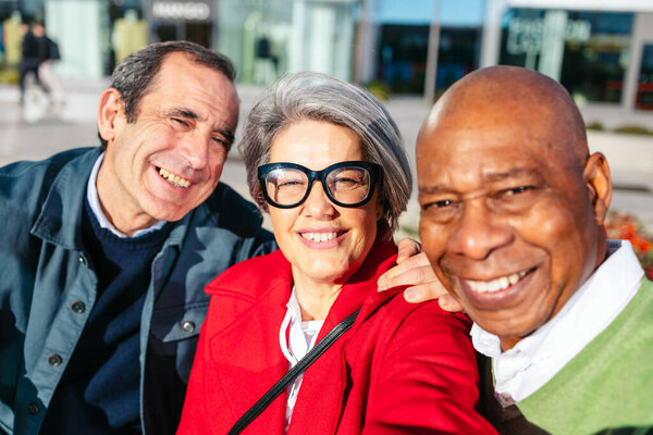 Cheerful friends walking together while shopping downtown
