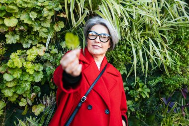 Yeşillik geçmişi olan, doğayı takdir eden olgun bir kadın.