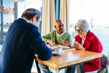 Arkadaşlar kahve içiyor, birlikte kahkaha atıyorlar.