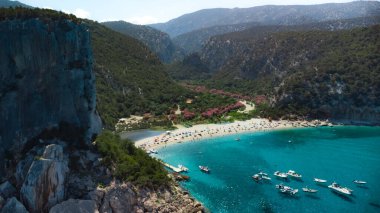 Sarp bir yamaçta, turkuaz suları ve yeşil bitki örtüsüyle güzel bir kumsal. Cala Luna, İtalya. Yüksek kalite fotoğraf