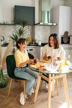 Anne ve kızı kaliteli vakit geçiriyorlar, parlak mutfaklarında kurabiye hazırlıyorlar.