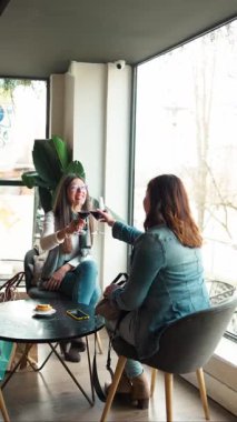 Yetişkin arkadaşlar şarap kadehlerini tokuşturur, güler ve akşam yemeği sırasında sıcak sohbetler ederler.