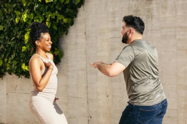 Mutlu dansçılar sokağın ortasında Küba salsası yapıp güneşli bir günün tadını çıkarıyorlar.