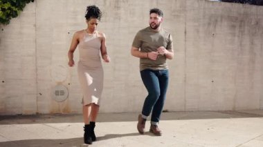 Şehir ortamında dans eden enerjik çift