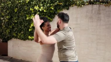 Mutlu çoklu etnik çift dışarıda salsa yapıyor.