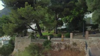 Kadın turist İspanya 'nın küçük Endülüs kasabası Mijas' ta gün batımına hayran. İHA atışı. Yüksek kalite 4k görüntü
