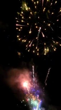 Gece gökyüzünde patlayan renkli havai fişekler yaz kutlamaları sırasında şenlikli bir atmosfer yaratıyor.