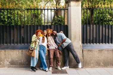 Bir grup neşeli çoklu etnik arkadaş birlikte selfie çekiyorlar, şehirde bir günün tadını çıkarıyorlar.