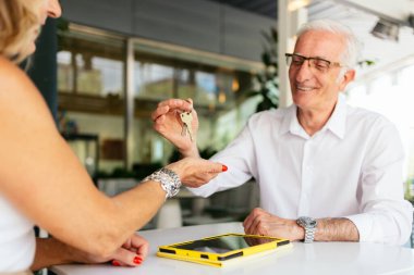 Üst düzey emlakçı kontratı imzaladıktan sonra müşteriye anahtarları veriyor.