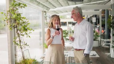 Yaşlı çift restoranda şarap içiyor.