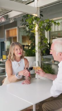 Yaşlı çift restoranda şarap içiyor.