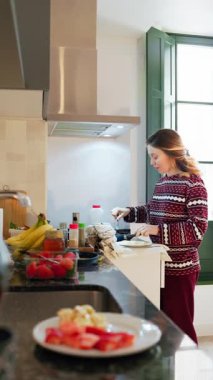 Kadın rahat mutfakta kahvaltı hazırlıyor.