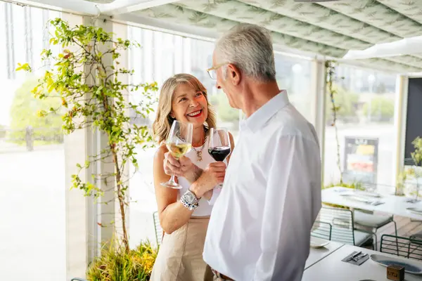 Son sınıf çifti restoran avlusunda şarap içiyor.