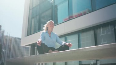 İş kadını iş alanında meditasyon yapıyor ve dinleniyor. Akıl sağlığı ve tükenmişlik kavramları. Yüksek kalite 4k görüntü