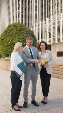 İş adamları bir ofis binası önünde sözleşmeyi gözden geçiriyorlar