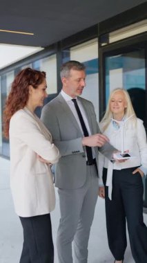 Minyatür bir rüzgar türbini inceleyen iş ekibi yenilenebilir enerji çözümlerini tartışıyor.