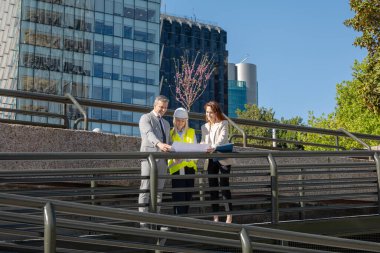 Şehir planlarını inceleyen mimarlar ve iş adamları