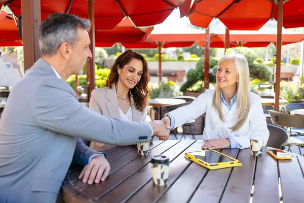 İş adamları kahve toplantısı için el sıkışıyor.