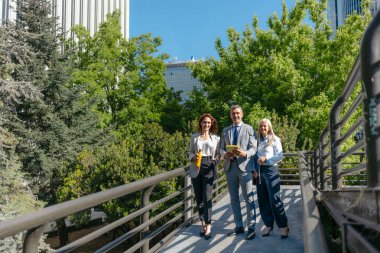 İş adamları şehir parkındaki yaya köprüsünde dijital tablet kullanıyorlar