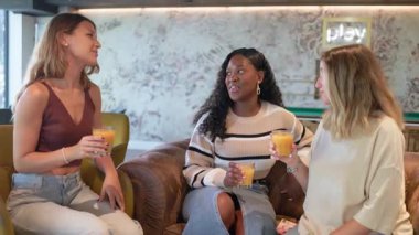 Sağlıklı meyve suyuyla kadeh kaldıran çeşitli kadın arkadaşlar.