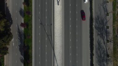 Arabalar güneşli bir günde çok şeritli bir yolda ilerliyor, uzun gölgeler, üst manzara, drone görüntüsü, kamera hareketi.