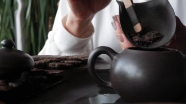 Çay odasında yeşil bilezik takan kadın elleri çaydanlığa çay döker yakın plan konsept çay seremonisi hafif arka plan alıştırmaları yapar.