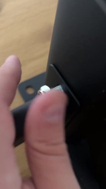 Büyük gümüş bir cıvatayı sıkıp çekiş çubuğunun siyah metal bileşenine somun yapıştıran birinin parmaklarının yakın çekimi, anahtar montaj adımını gösterir..