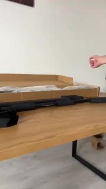 Bir insanın elinde çeşitli vida, cıvata ve duvar tıkaçları içeren şeffaf plastik bir torba var. Tahta bir yüzey üzerindeki çekme çubuğunun diğer bileşenleriyle boks yaparken serili..