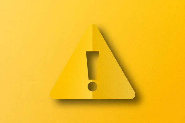 Yellow paper cut into exclamation mark shapes. warning sign set on yellow paper background