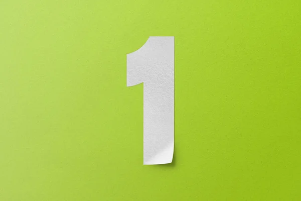 白い紙のタイプ紙のアルファベットナンバー1緑の背景に隔離 — ストック写真