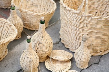 Woven wicker wine bottle and baskets: Italian craftsmanship clipart