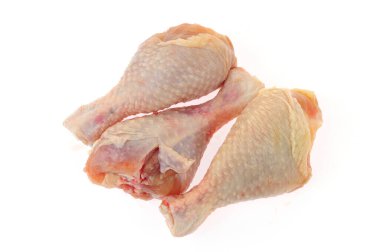 Beyaz arka planda çiğ tavuk bacağı.