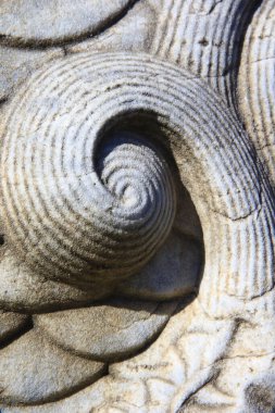 Taşın üzerindeki eski bir süs. Yakın plan dikişsiz doku. Taş dokusu. Taştaki desen. Kabartmalı desen.