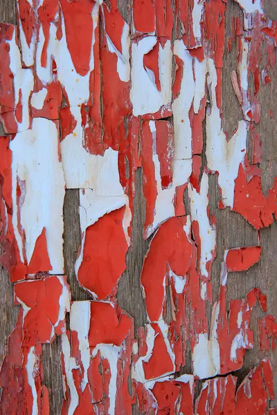 Paint peeling off the wooden board, red