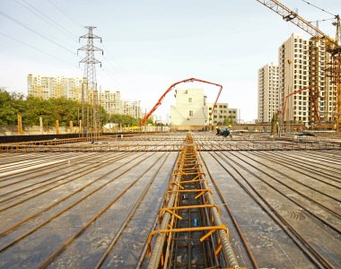 İnşaat alanında beton döşeme için takviye metal iskeleti yapan işçiler