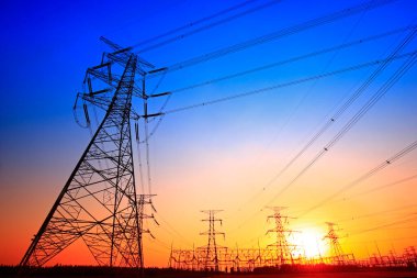 Elektrik kuleleri, güç ekipmanları, gün batımında.