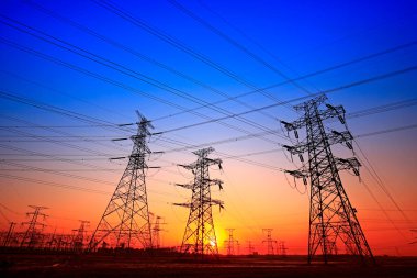 Elektrik kuleleri, güç ekipmanları, gün batımında.