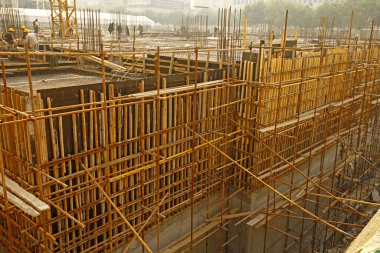 İnşaat alanında beton döşeme için takviye metal iskeleti yapan işçiler