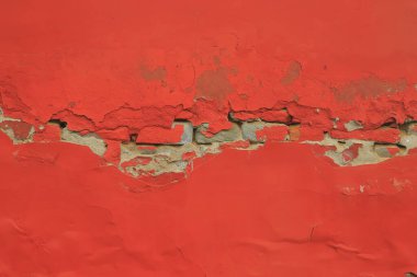 Kırmızı duvardaki boya soyuluyor.