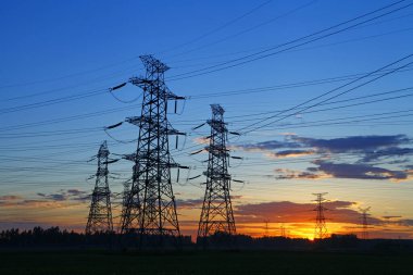 Elektrik kuleleri, günbatımında endüstriyel enerji tesisleri