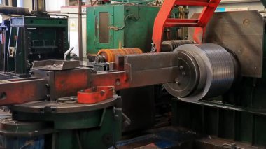 Çelik fabrikası atölyesinde mekanik ekipmanlar çalışıyor.